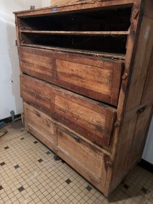 an old wooden chest of drawers in a room with a tiled floor