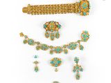 a collection of turquoise and gold jewelry including a bracelet, broochle, and earrings
