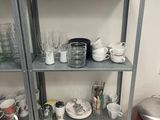 many cups and mugs on the shelves in the kitchen