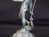 bronze statue of a man holding a flag on a marble base