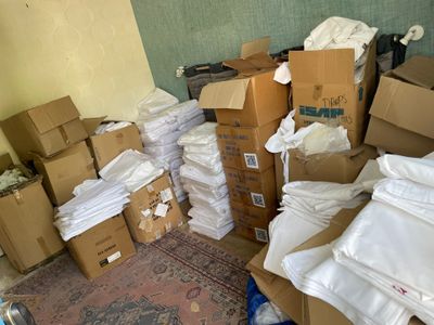 une pile de cartons et une pile de vêtements par terre