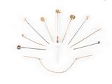 une horloge composée d'épingles en or et en argent sur fond blanc