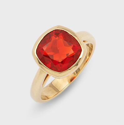 a close up of a gold ring with a red stone
