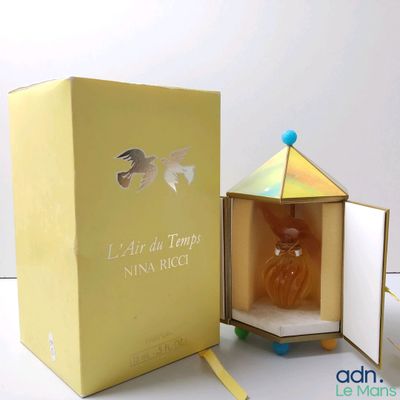 a yellow box with a perfume bottle inside of it