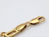 a close up of a gold chain on a white surface