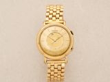 a close up of a gold wrist watch on a white surface