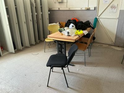 a room with a table, chairs, and a refrigerator in it