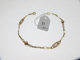un bracelet en chaîne d'or auquel est attachée une plaque