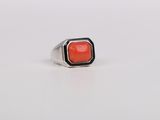 a close up of a ring with a red stone in it