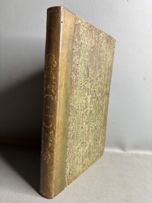 an old book sitting on top of a table next to a white wall