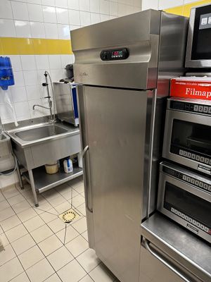 des fours en acier inoxydable dans une cuisine professionnelle carrelée de jaune et de blanc