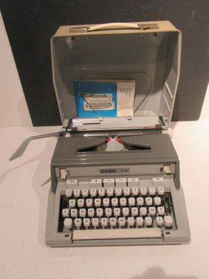 an old typewriter sitting on a table next to a box