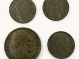 four coins of different sizes and shapes on a white surface