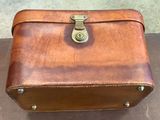 a brown leather suitcase sitting on a table