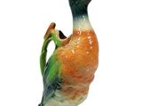 a ceramic duck with a green beak and orange body