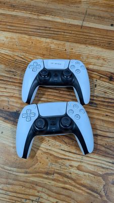 deux manettes de jeu vidéo blanches posées sur un parquet