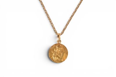 a gold necklace with a coin on a chain