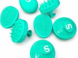 plusieurs brosses à cheveux et peignes verts posés sur une surface blanche