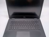 the dell laptop is open on a white surface with a black keyboard