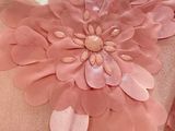 a pink dress with a flower on it on a mannequin