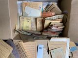 a cardboard box full of old papers and other items