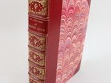 un livre rouge avec des bordures dorées et une couverture rouge
