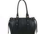 Le sac à main en cuir noir est posé sur une surface blanche.
