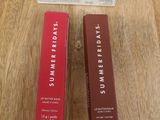 two boxes of lip butter sitting on top of a wooden table