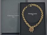 a box with a gold chain bracelet and a star charm