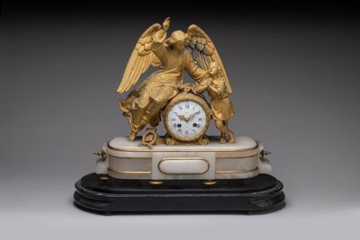 a gold clock with an angel on top of it