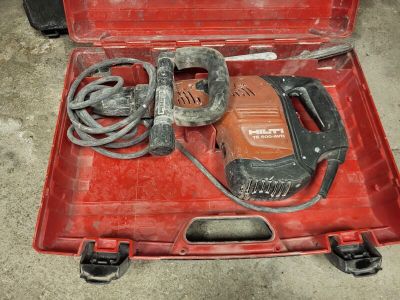 une mallette à outils rouge contenant une perceuse et un cordon d'alimentation