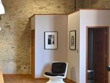 an image of a living room with wood floors and a stone wall