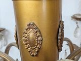 a gold vase that is sitting on top of a chandelier