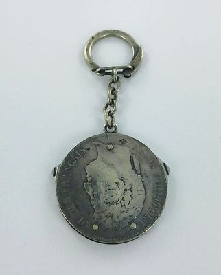 an old coin with a keychain hanging from it ' s side