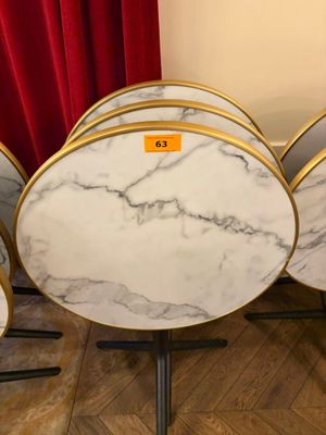 quatre tables rondes en marbre ornées d'une bordure dorée