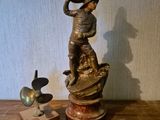 une statue représentant un homme coiffé d'un chapeau, posée sur une table