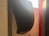 a toilet in the corner of a bathroom with a black seat