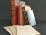 several old books are stacked on top of each other on a table