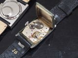 two watches that are sitting on a black table