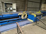 a machine that is cutting metal bars in a factory