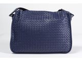 a blue woven leather shoulder bag with a zipper closure