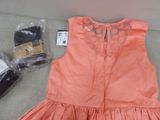 a pink dress and a pair of shoes on the floor