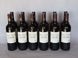 six bottles of wine are lined up in a row on a table