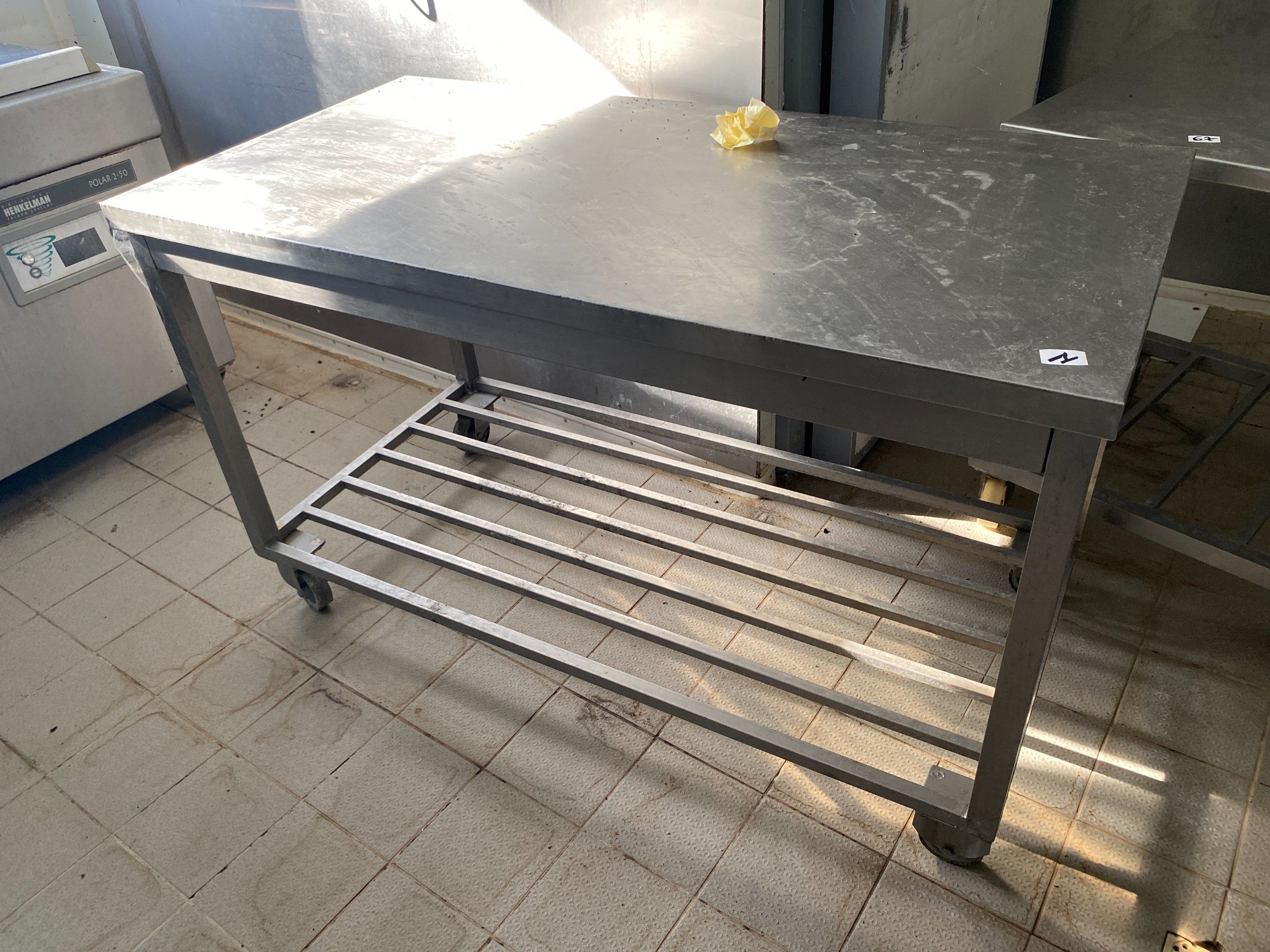 Une table rectangulaire en inox à claies d'entrejambe, sur r…