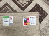 a laptop computer sitting on top of a rug on the floor