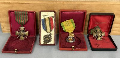 quatre médailles et une médaille se trouvent dans un écrin posé sur une table