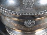a silver plate with a lid on a black table
