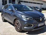 the grey car is parked in front of a white building
