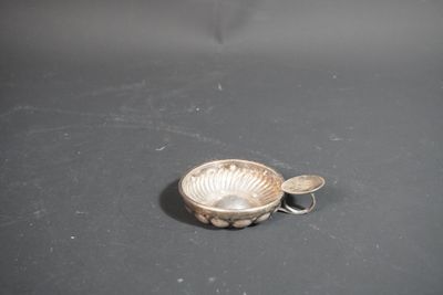 a small silver bowl with a spoon on a table