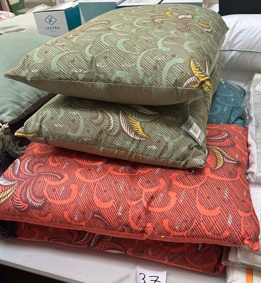 many pillows and pillows on a table in a room